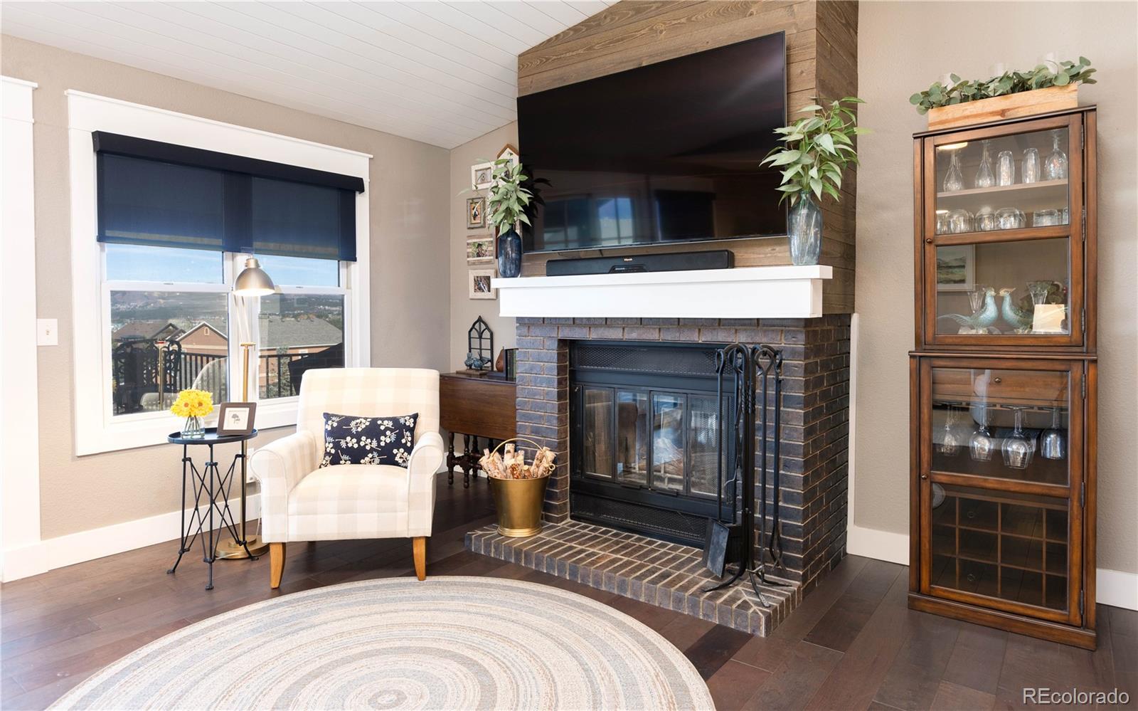 17840 New London Road Monument, CO 80132 - Photo 7 of 47 a living room with furniture a flat screen tv and a fireplace