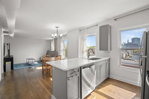 a kitchen with a sink stove and wooden floor
