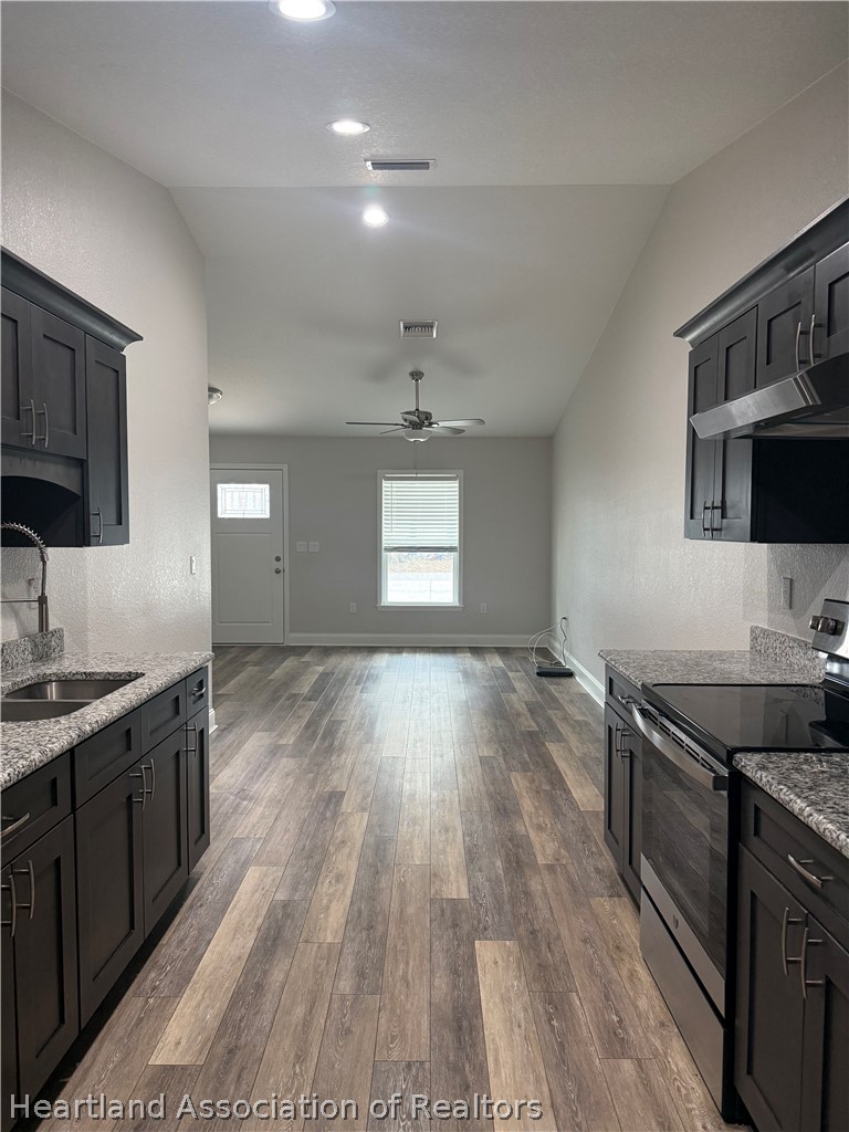 809 Redding Street Zolfo Springs, FL 33890 - Photo 3 of 8 a kitchen with granite countertop a sink stove and cabinets
