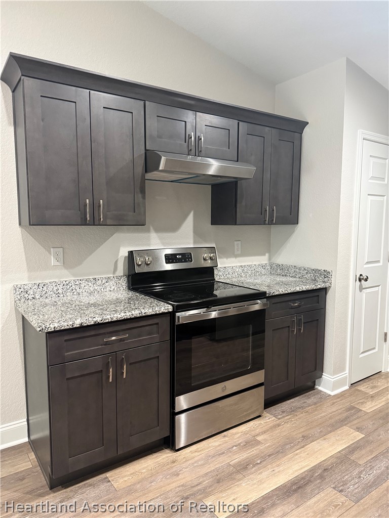 809 Redding Street Zolfo Springs, FL 33890 - Photo 5 of 8 a kitchen with stainless steel appliances granite countertop a stove a sink and a microwave