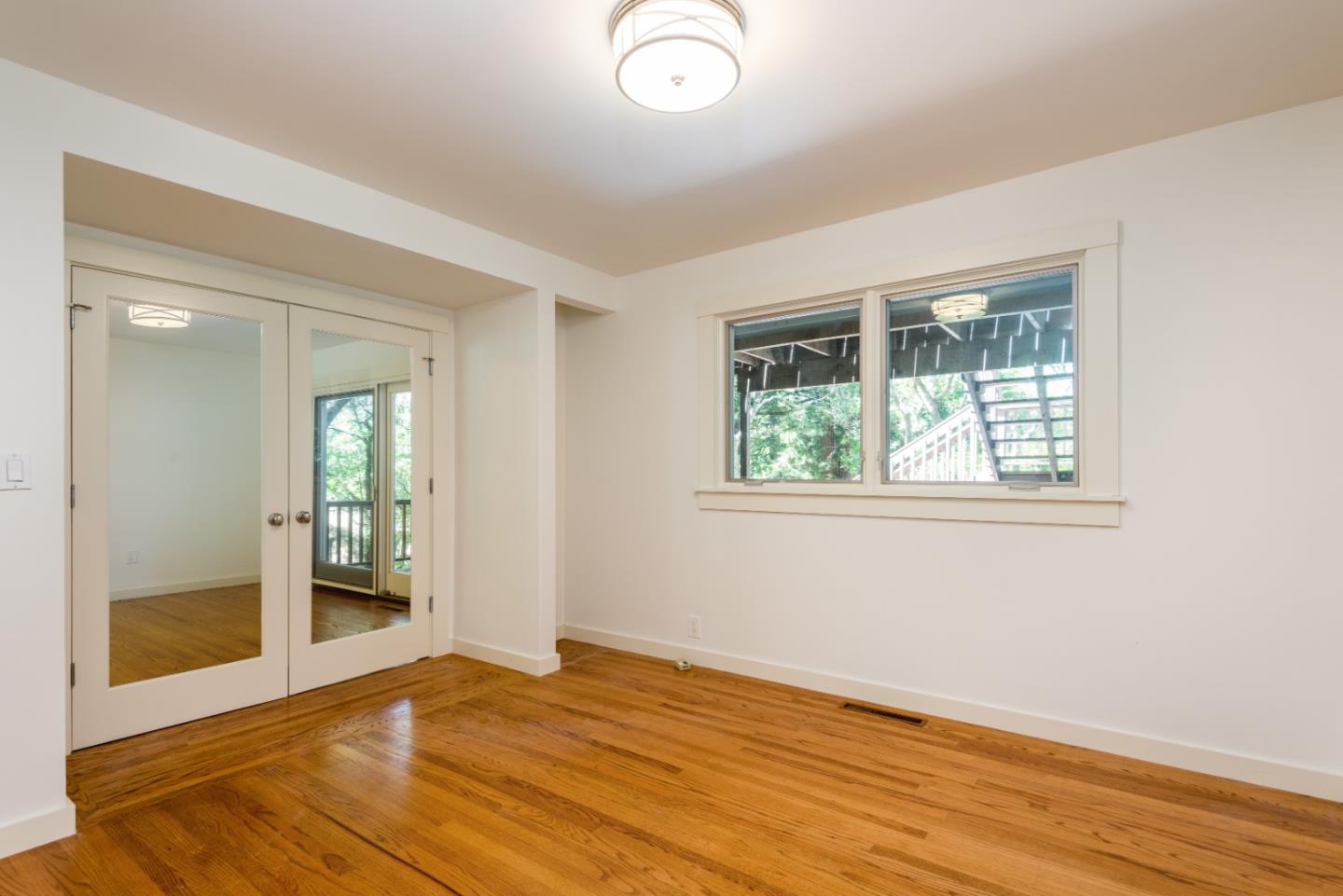 790 Patrol Road Woodside, CA 94062 - Photo 16 of 26 an empty room with wooden floor and windows
