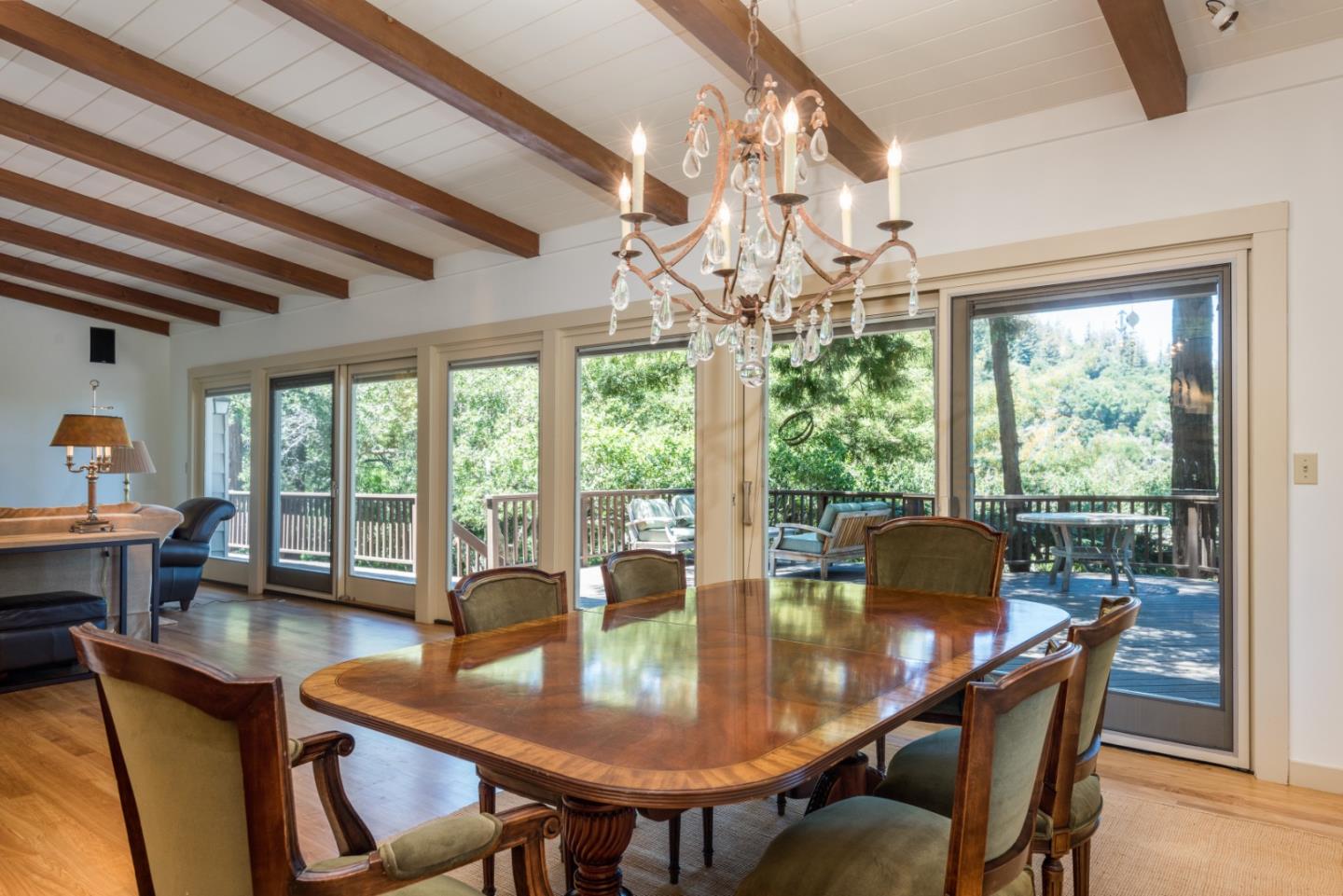 790 Patrol Road Woodside, CA 94062 - Photo 7 of 26 a view of a dining room with furniture a chandelier and large windows