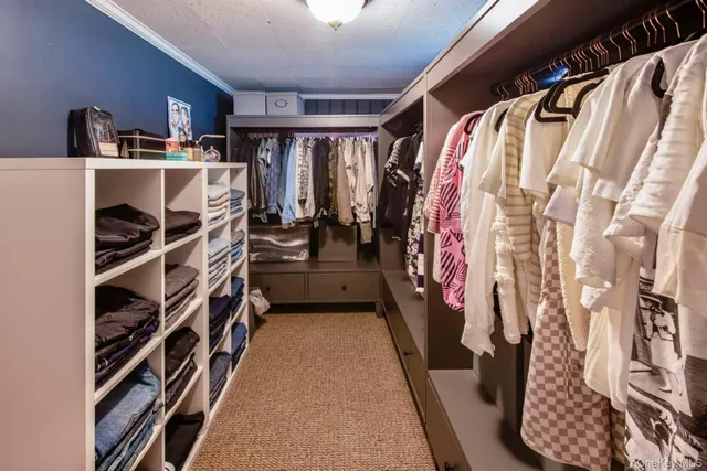 a view of walk in closet with clothes and shoes