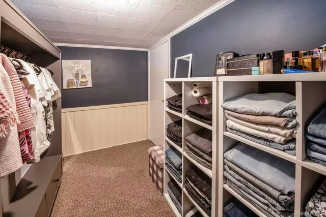 a view of walk in closet with clothes and shoes