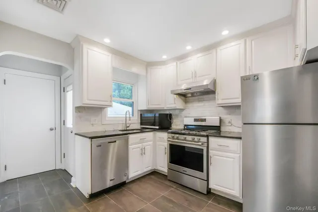 a kitchen with a white stove top oven and refrigerator