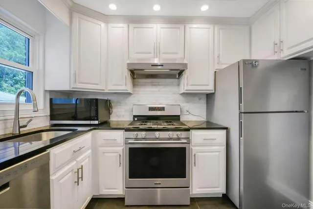 a kitchen with cabinets stainless steel appliances and a counter space