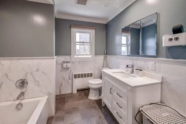 a bathroom with a double vanity sink a mirror and a bathtub