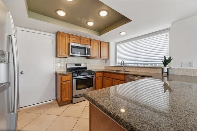 a kitchen with stainless steel appliances granite countertop a sink and a stove