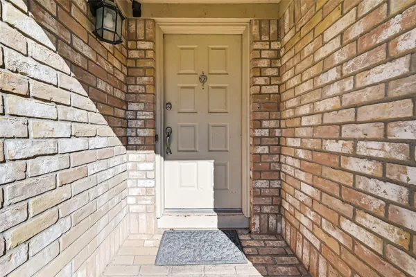a view of wooden door and brick wall