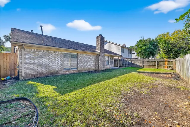 a view of a house with backyard and a tree