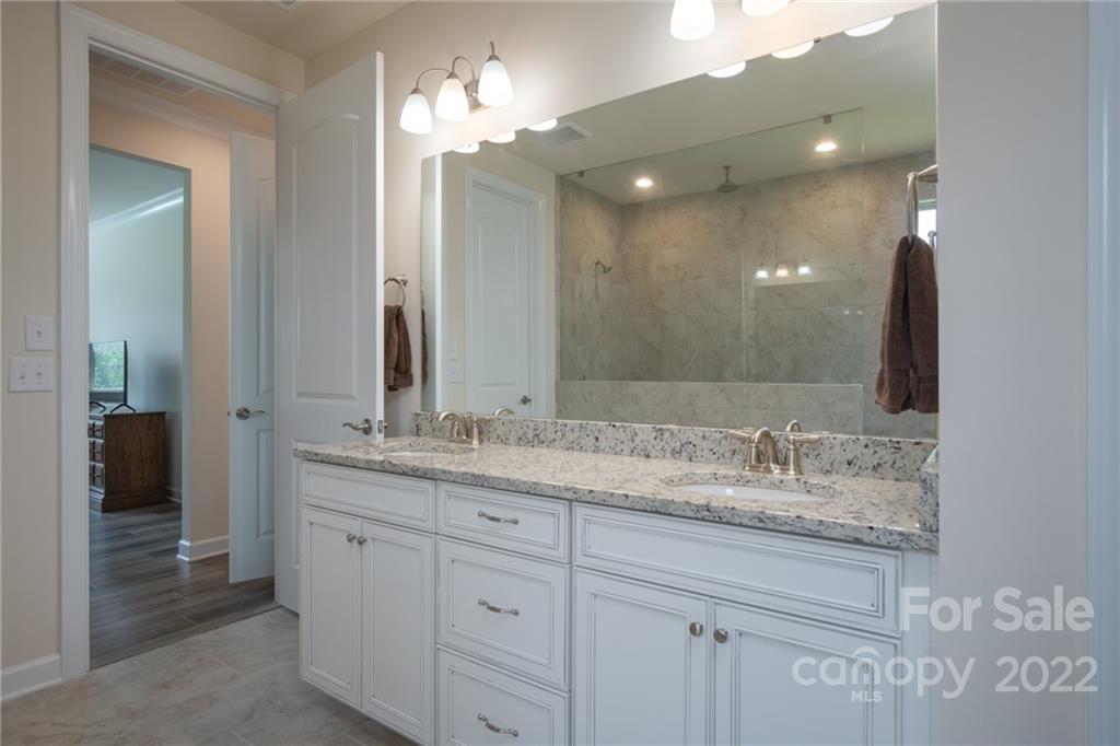 1213 Independence Street Tega Cay, SC 29708 - Photo 22 of 35 a bathroom with a granite countertop double vanity sink and a mirror
