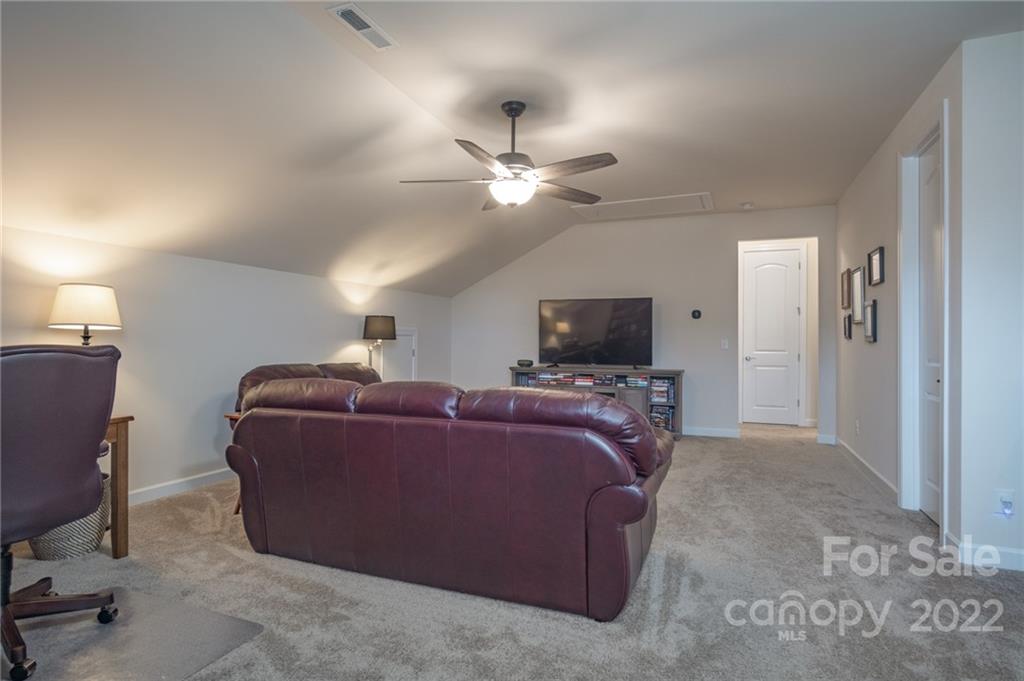 1213 Independence Street Tega Cay, SC 29708 - Photo 24 of 35 a living room with furniture a flat screen tv and a ceiling fan