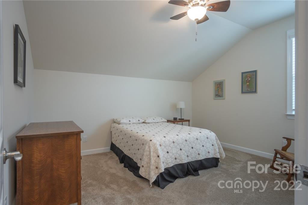 1213 Independence Street Tega Cay, SC 29708 - Photo 26 of 35 a bedroom with a bed and a chandelier
