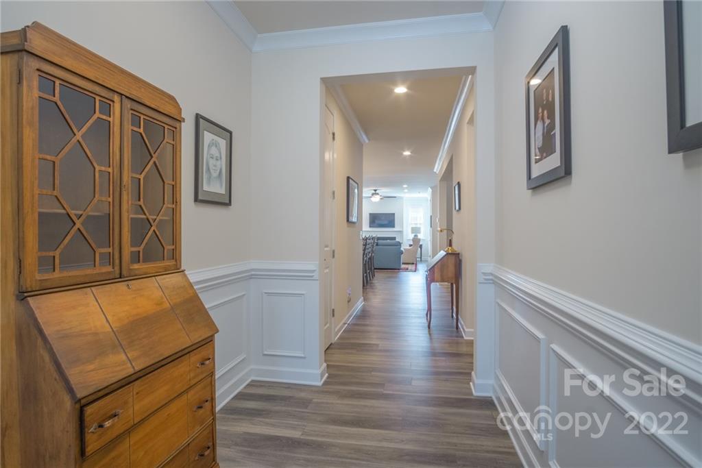 1213 Independence Street Tega Cay, SC 29708 - Photo 5 of 35 a hallway with wooden floor windows and a kitchen view
