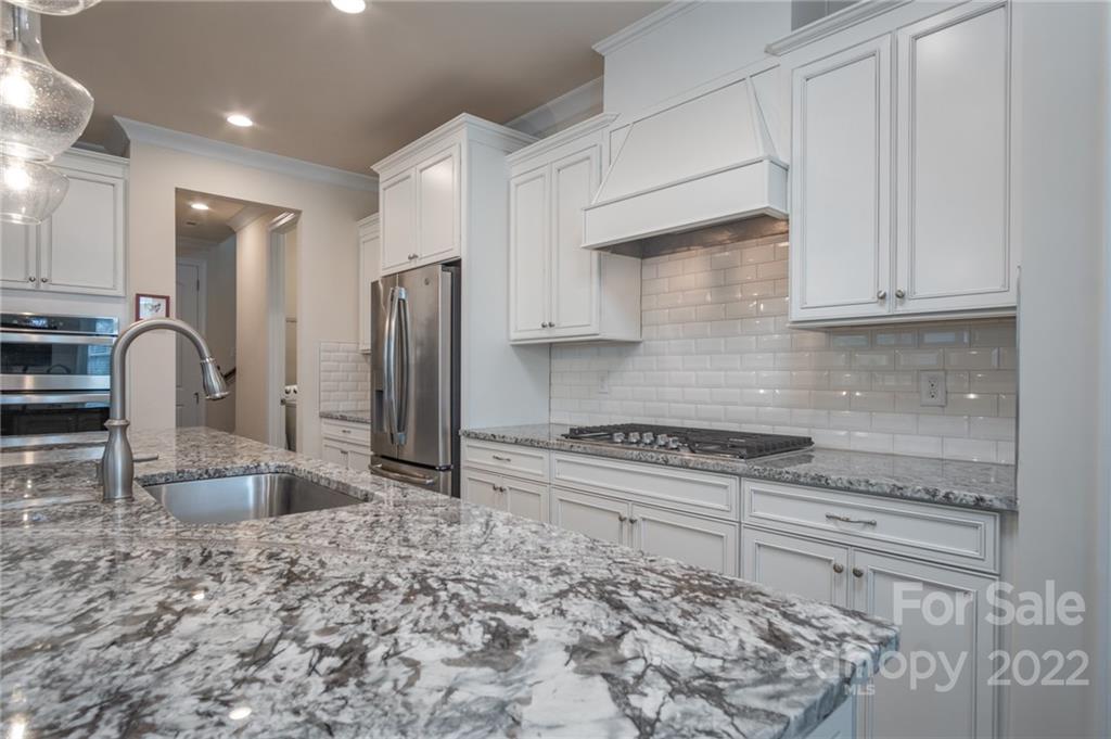 1213 Independence Street Tega Cay, SC 29708 - Photo 9 of 35 a kitchen with stainless steel appliances granite countertop a sink stove and refrigerator