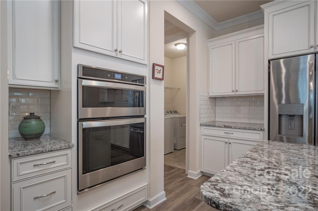 1213 Independence Street Tega Cay, SC 29708 - Photo 10 of 35 a kitchen with granite countertop white cabinets and stainless steel appliances