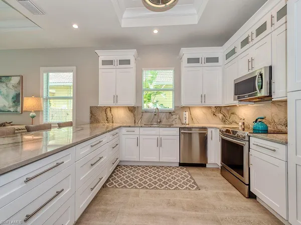 a kitchen with granite countertop cabinets stainless steel appliances a sink and a window