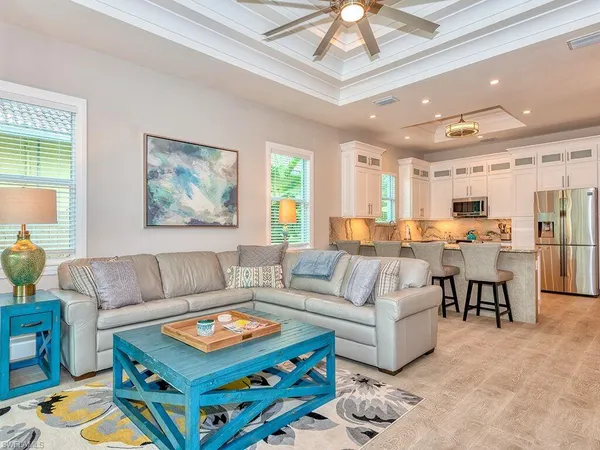 a living room with furniture and a dining table with kitchen view