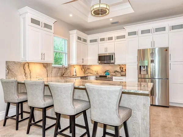 a kitchen with stainless steel appliances granite countertop a stove a refrigerator a table and chairs