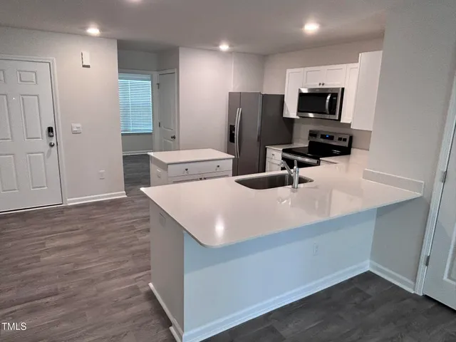 a kitchen with kitchen island a sink appliances and cabinets