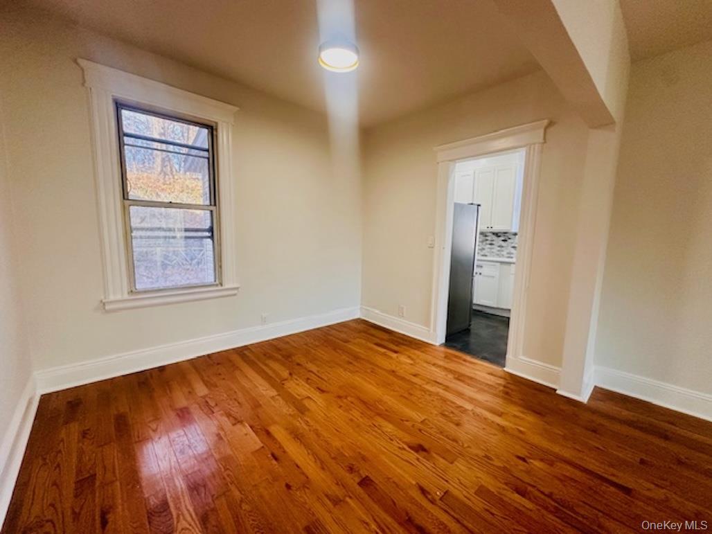 5517 Fieldston Road Bronx, NY 10471 - Photo 6 of 28 a view of an empty room with wooden floor and a window