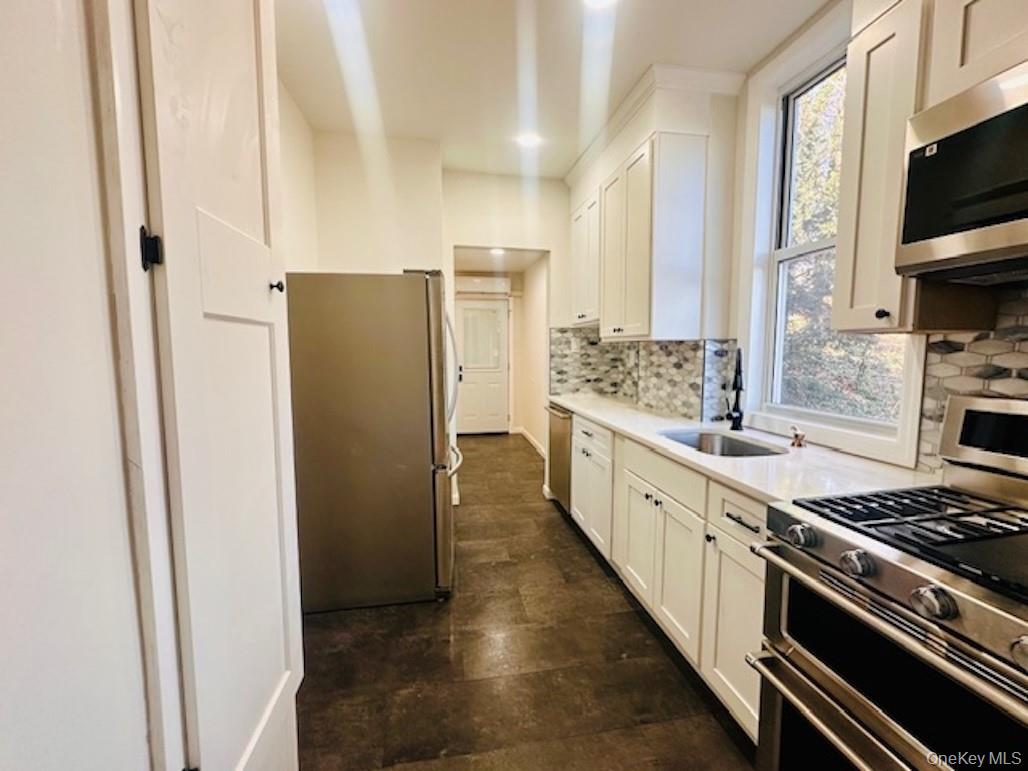 5517 Fieldston Road Bronx, NY 10471 - Photo 7 of 28 a large kitchen with a stove and a refrigerator