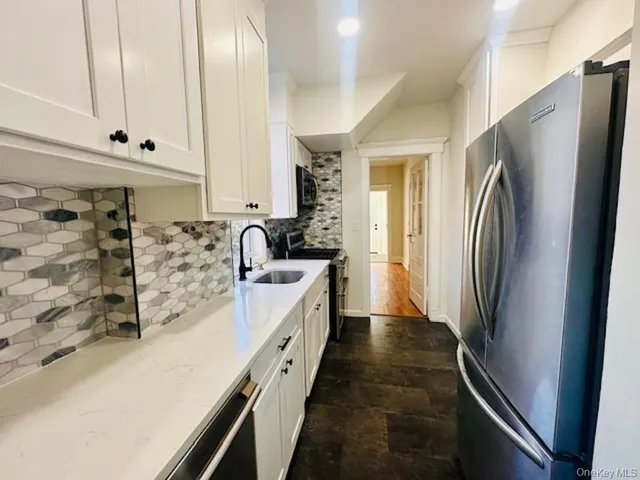 a kitchen with stainless steel appliances granite countertop a refrigerator a stove and a sink