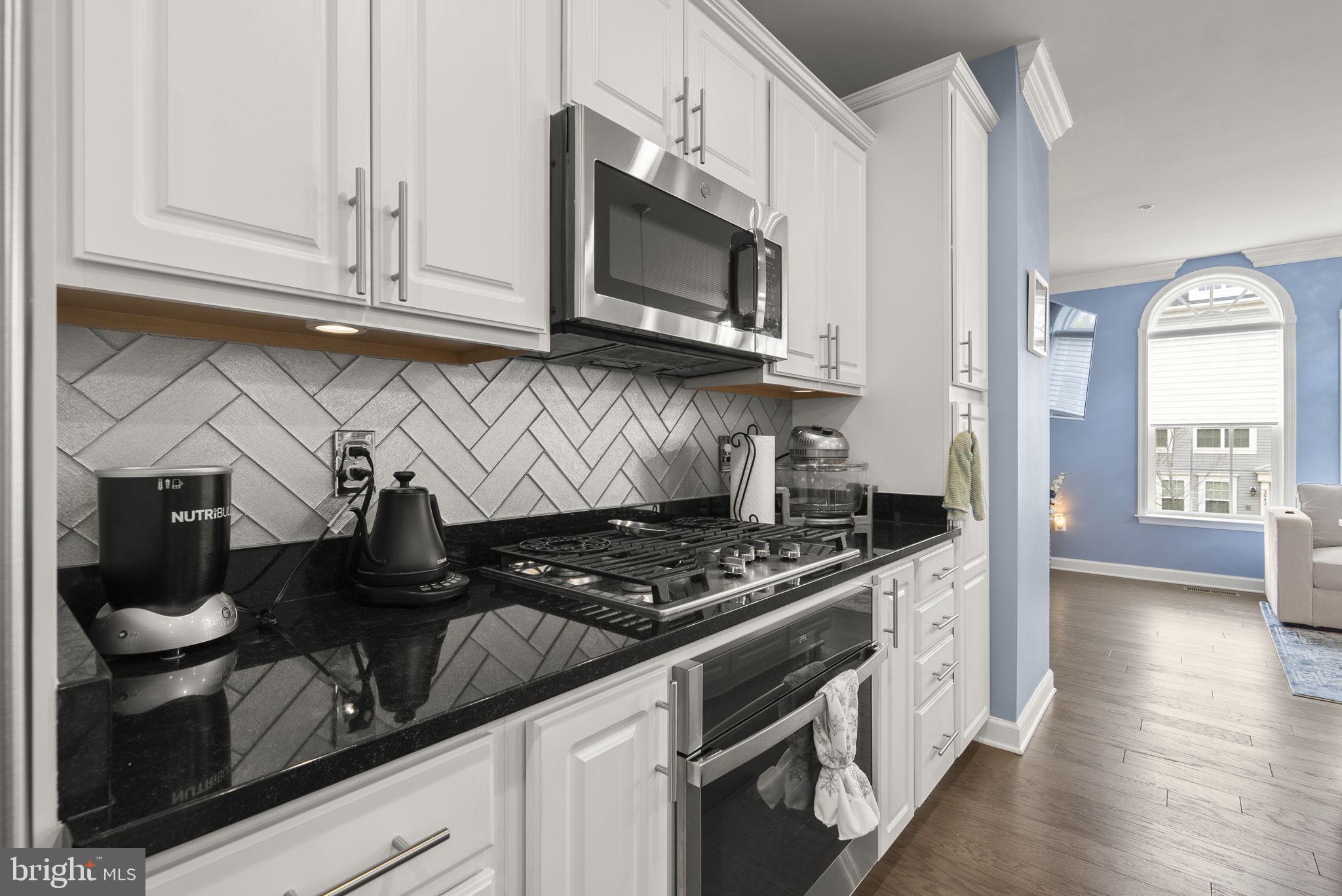 3043 Mia Lane Bowie, MD 20721 - Photo 13 of 44 a kitchen with stainless steel appliances granite countertop a stove a microwave and cabinets