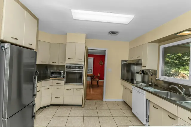 a kitchen with stainless steel appliances a refrigerator sink and stove