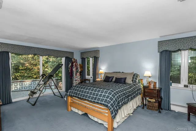 a bedroom with a bed and large windows