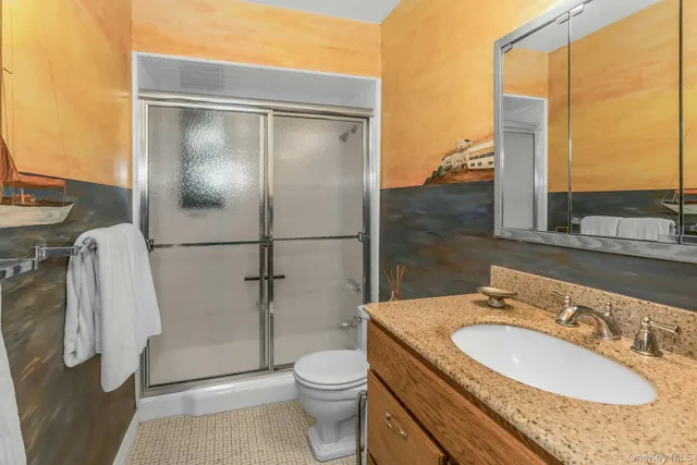 a bathroom with a granite countertop sink toilet and shower