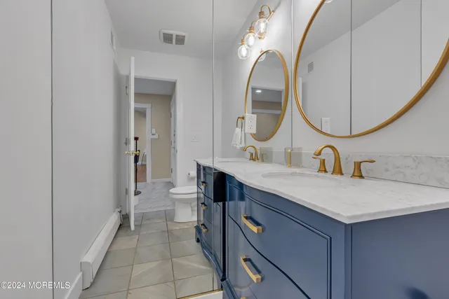 a bathroom with a toilet sink and mirror