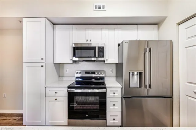 a kitchen with stainless steel appliances a refrigerator stove and microwave