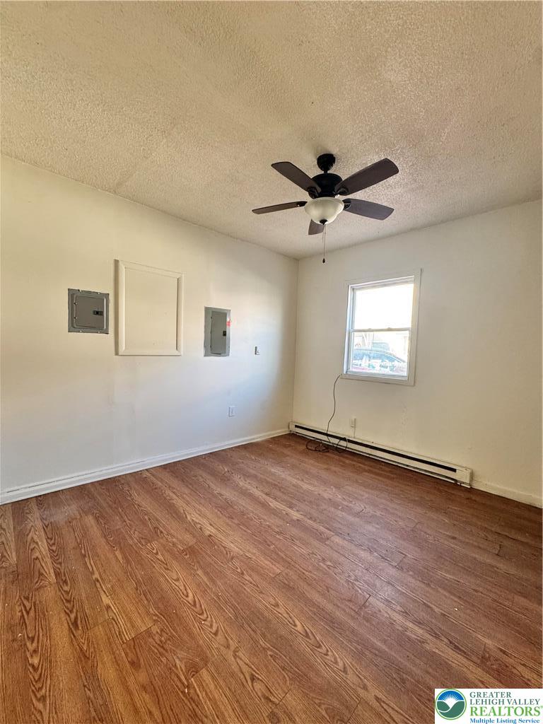 1218 Mechanic Street, Unit 2 Bethlehem, PA 18015 - Photo 4 of 9 an empty room with wooden floor chandelier fan and windows
