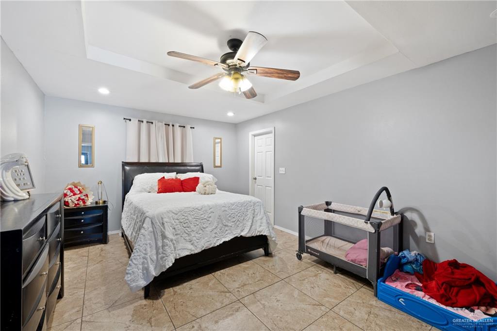 320 Violet Avenue Mission, TX 78574 - Photo 12 of 14 a bedroom with a bed and a chandelier