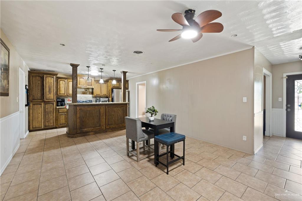 320 Violet Avenue Mission, TX 78574 - Photo 4 of 14 a kitchen with stainless steel appliances kitchen island granite countertop dining table chairs and a refrigerator