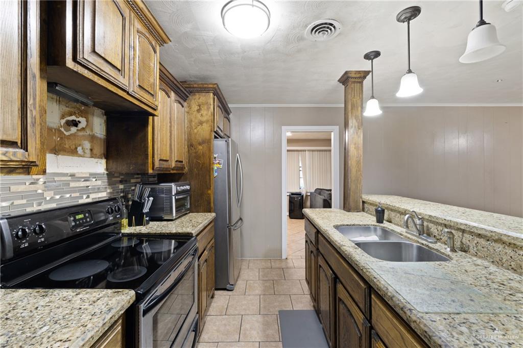 320 Violet Avenue Mission, TX 78574 - Photo 5 of 14 a kitchen with a sink stove and refrigerator