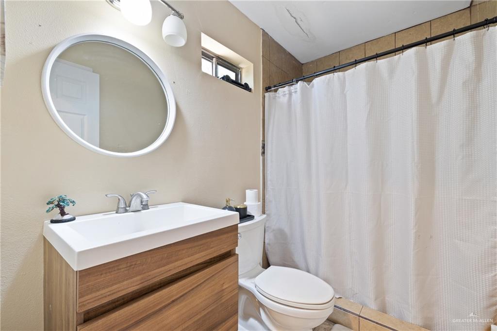 320 Violet Avenue Mission, TX 78574 - Photo 10 of 14 a bathroom with a sink a toilet and a mirror