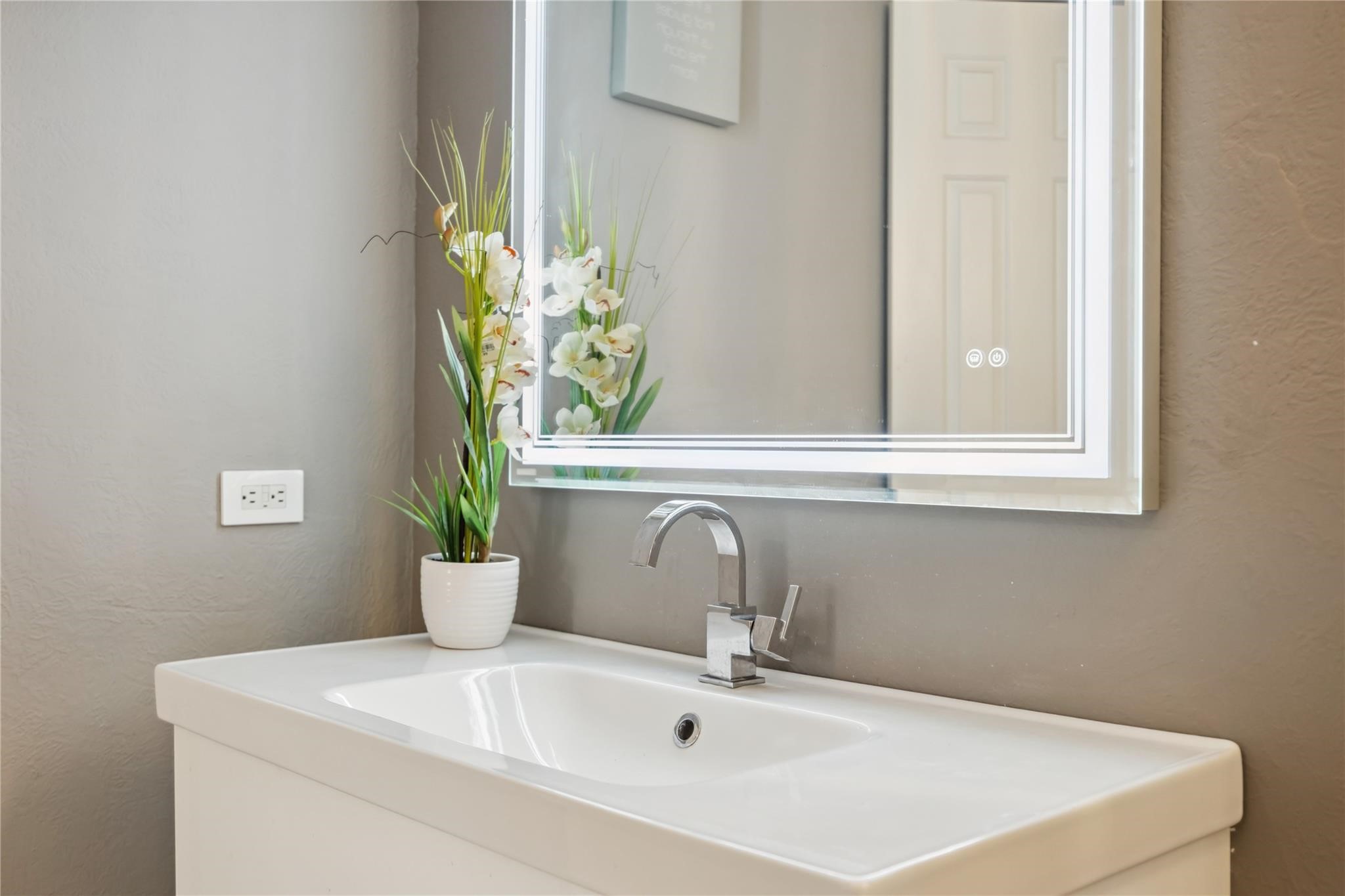 3525 Sage Road, Unit 1713 Houston, TX 77056 - Photo 19 of 25 Vanity with sleek chrome faucet and backlit mirror—designed for style and functionality.