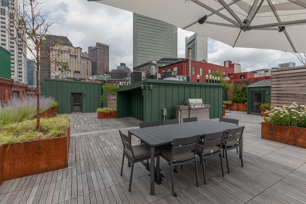 112 Beach Street, Unit 1 Boston, MA 02111 - Photo 1 of 20 a view of a patio with table and chairs with wooden floor and plants