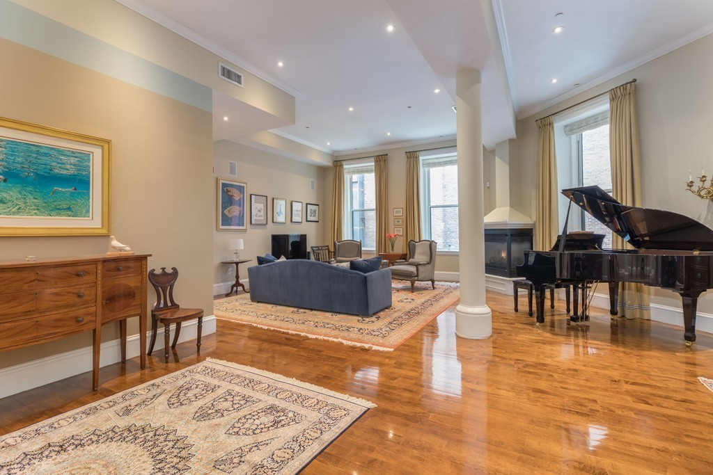 112 Beach Street, Unit 1 Boston, MA 02111 - Photo 2 of 20 a living room with furniture a dining table and a flat screen tv
