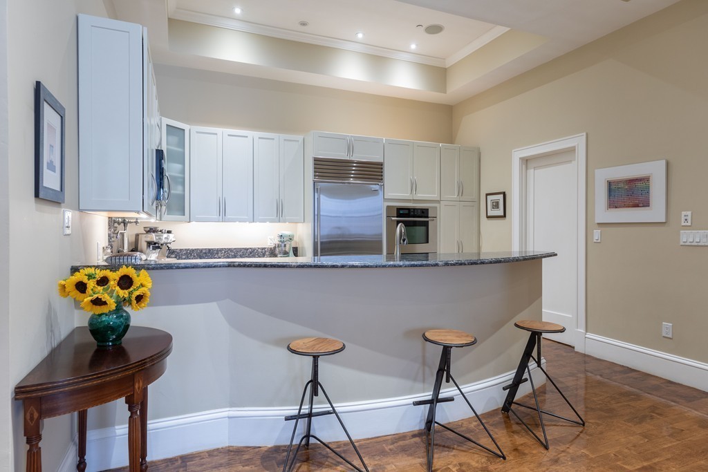 112 Beach Street, Unit 1 Boston, MA 02111 - Photo 8 of 20 a kitchen with stainless steel appliances granite countertop a chairs and a refrigerator