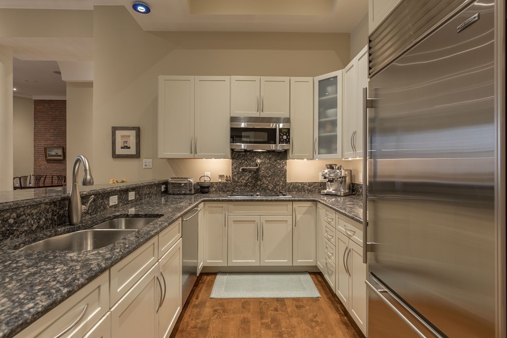 112 Beach Street, Unit 1 Boston, MA 02111 - Photo 9 of 20 a kitchen with stainless steel appliances granite countertop a sink stove and refrigerator