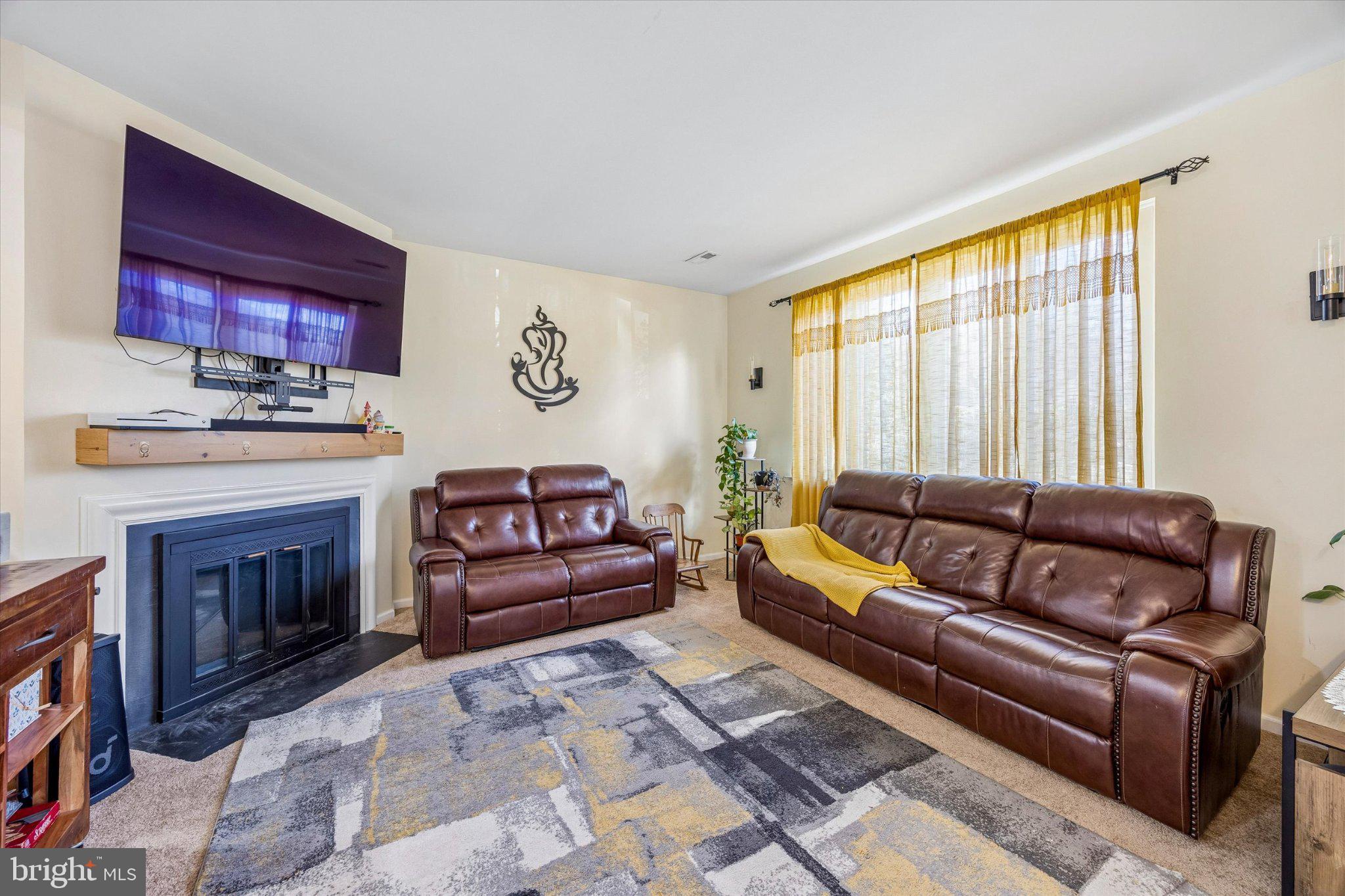 24 Independence Place Newtown, PA 18940 - Photo 2 of 15 a living room with furniture a fireplace and a large window