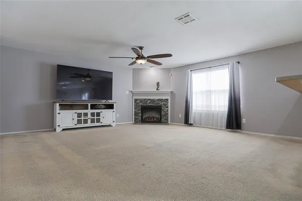 a view of an empty room with a fireplace and a flat screen tv