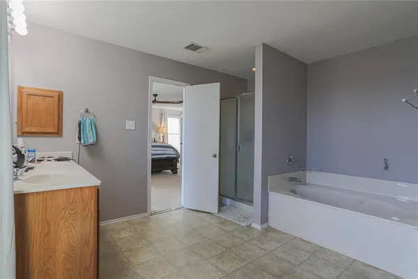 a bathroom with a tub sink and mirror