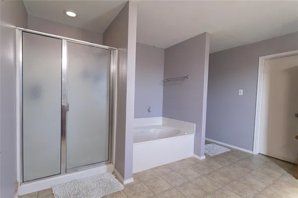 a spacious bathroom with a bathtub and a shower