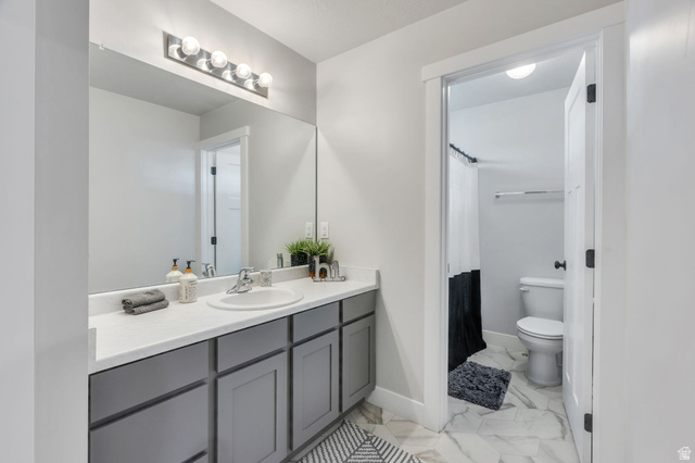 252 North Sunrise Rnch Drive Mapleton, UT 84664 - Photo 27 of 62 Bathroom featuring a single vanity with a white countertop, undermount sink, and gray cabinetry