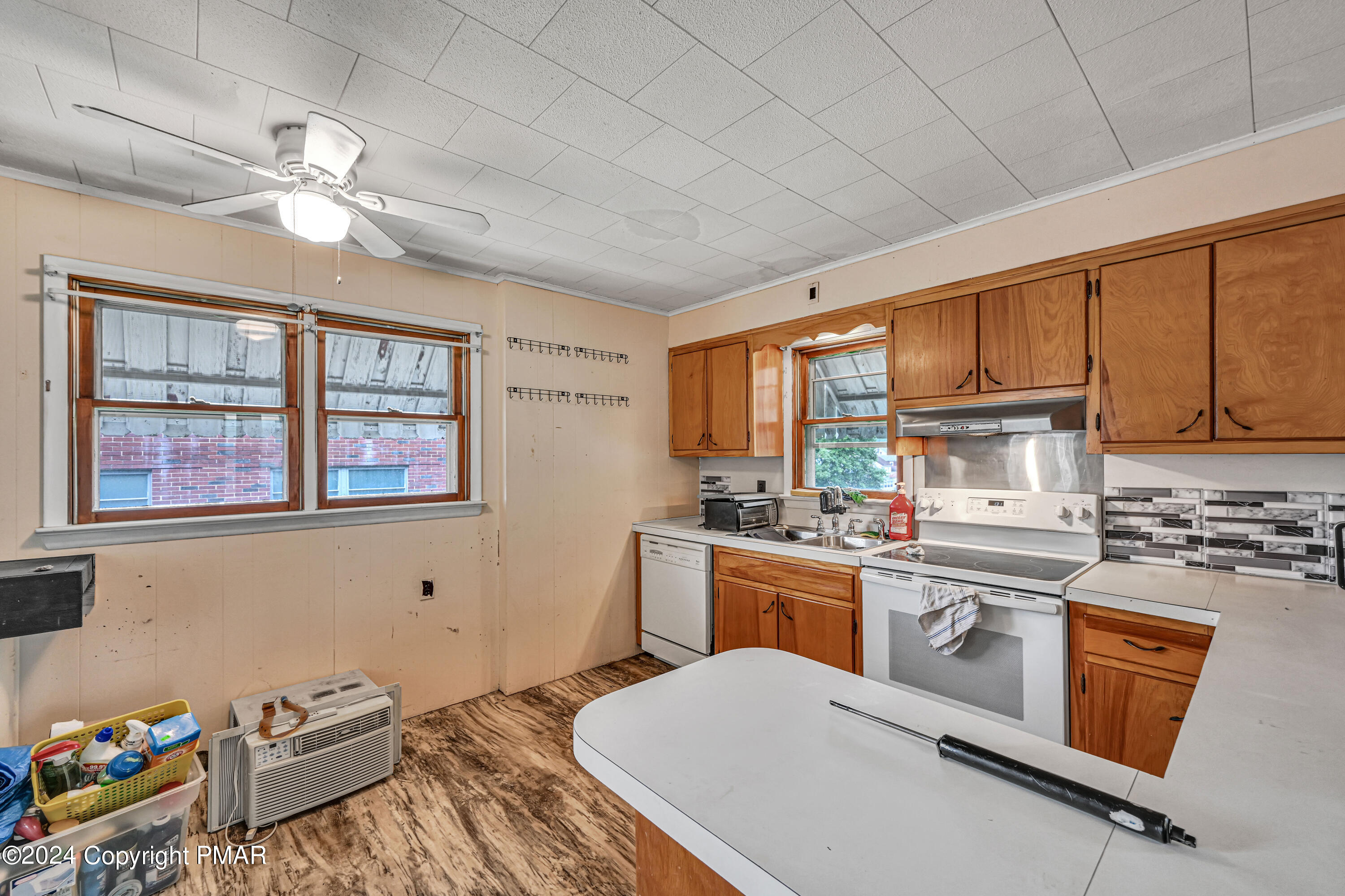128 North West Street Williamstown, PA 17098 - Photo 9 of 23 a kitchen with a stove a sink dishwasher and white cabinets with wooden floor