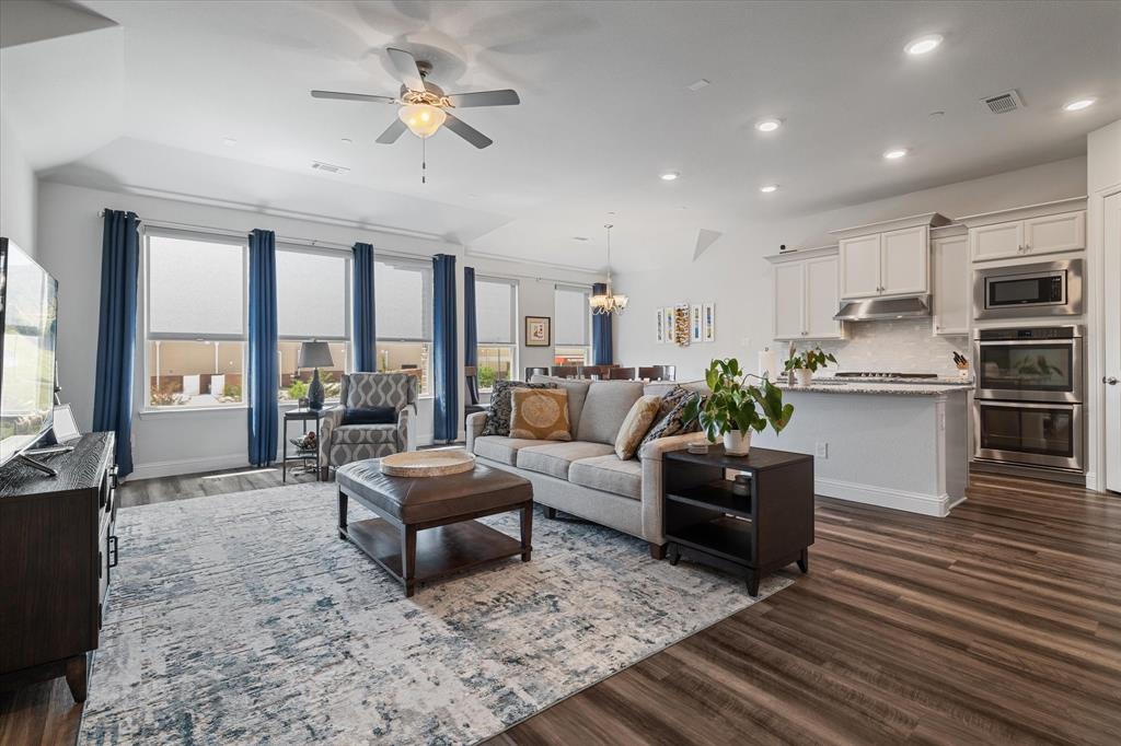 a living room with furniture kitchen view and a large window